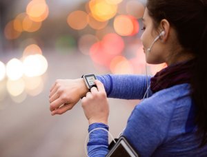 Fitness App Joggerin mit Smart Watch und Kopfhörern