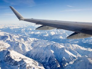 Flugzeug fliegt über schneebedeckte Alpen